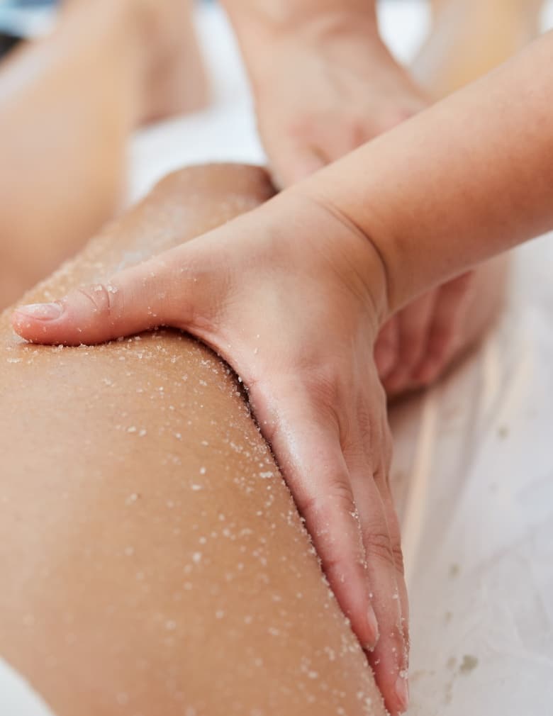 Mains d un professionnelle applique un soin sur la jambe d une patiente soins de corps- Hind clinique de beaute Montpellier