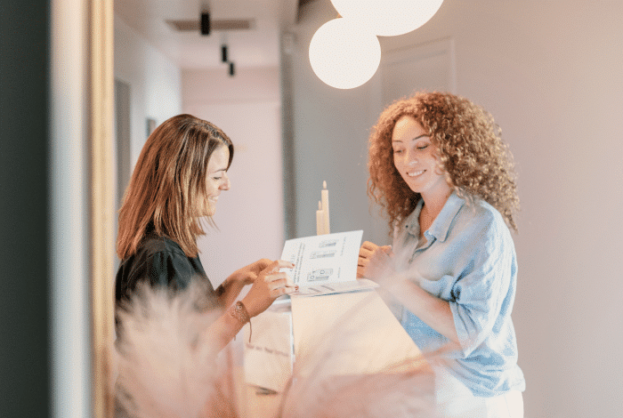 Deux belles femmes tenant un flyer de la Hind clinique de beaute Montpellier